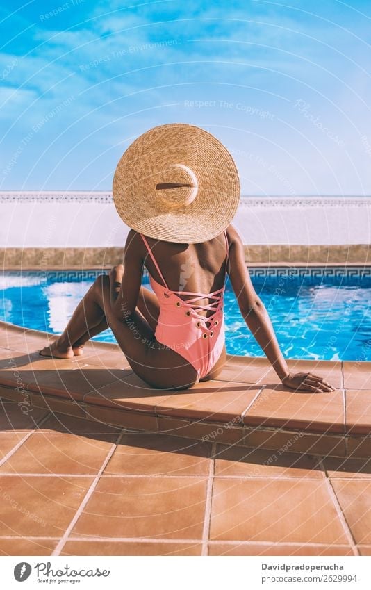 Black woman seating down in a swimming pool side Woman Ethnic Swimming pool Summer Sunbathing Vacation & Travel tan Horizontal tanning Relaxation Copy Space