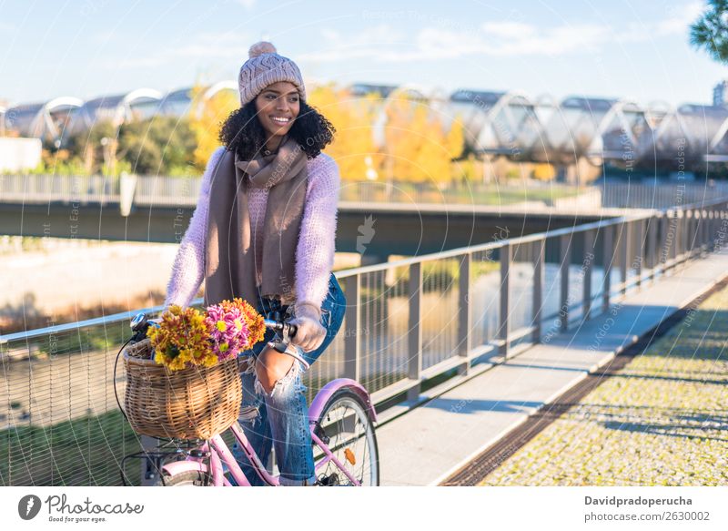 Black young woman riding a vintage bicycle Bicycle Vintage Basket Girl Woman Mixed race ethnicity Beautiful Retro Flower Happy Bouquet Winter Autumn