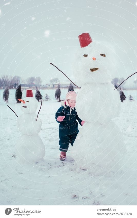 Little girl making a snowman Lifestyle Joy Happy Winter Snow Child Human being Girl 1 3 - 8 years Infancy Snowfall Clothing To enjoy Make Small Cute White