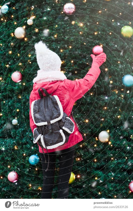 Young girl standing at front of big Christmas tree Lifestyle Joy Winter Snow Decoration Christmas & Advent Human being Young woman Youth (Young adults) 1 Tree