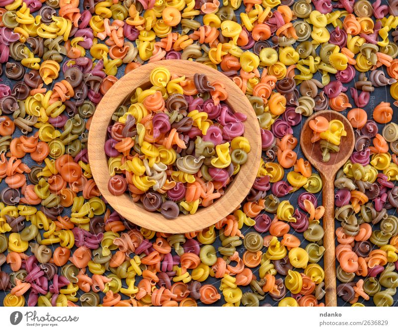 multicolored spiral raw pasta fusilli in a wooden bowl Dough Baked goods Nutrition Dinner Diet Bowl Spoon Wood Eating Fresh Brown Yellow Green Red Colour