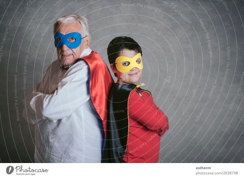 Grandfather With Grandson dressed as a superhero on gray background Lifestyle Joy Adventure Feasts & Celebrations Carnival Fairs & Carnivals Success Retirement