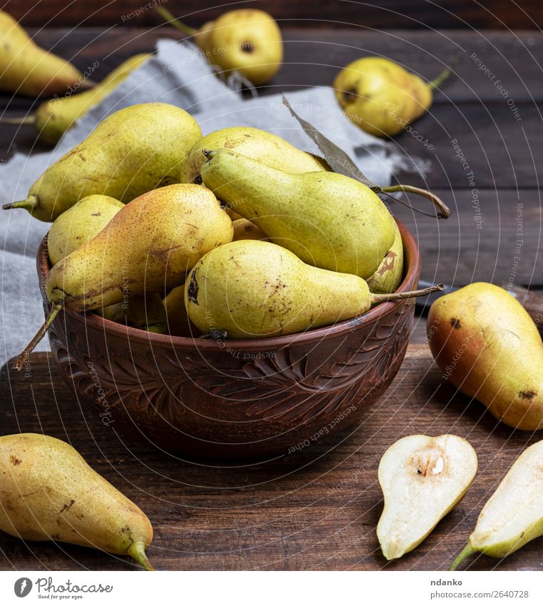 ripe green pears in a brown clay bowl Fruit Nutrition Vegetarian diet Diet Bowl Table Nature Autumn Wood Old Eating Fresh Delicious Natural Above Juicy Yellow