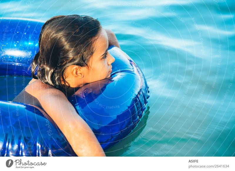 Happy little girl floating with a ring in the water Lifestyle Joy Beautiful Relaxation Swimming pool Leisure and hobbies Playing Vacation & Travel Summer Beach