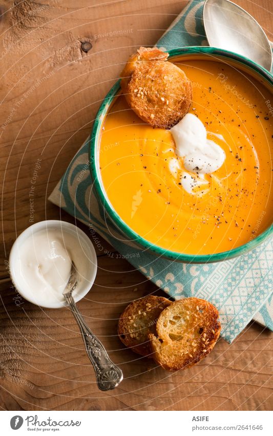 Pumpkin soup with coconut cream and spices Cheese Vegetable Bread Herbs and spices Vegetarian diet Diet Bowl Winter Autumn Wood Orange butternut squash soup