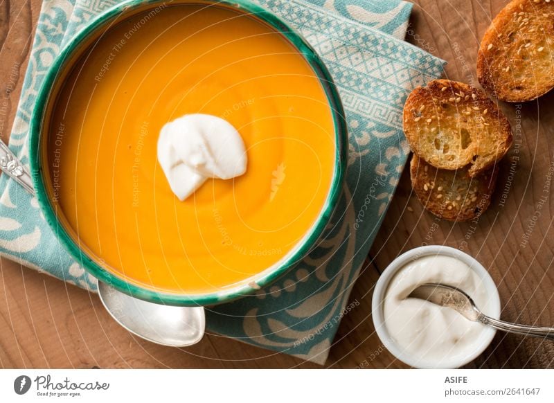 Pumpkin soup with coconut cream Cheese Vegetable Bread Vegetarian diet Diet Bowl Winter Hallowe'en Autumn Wood Delicious Orange butternut squash soup puree