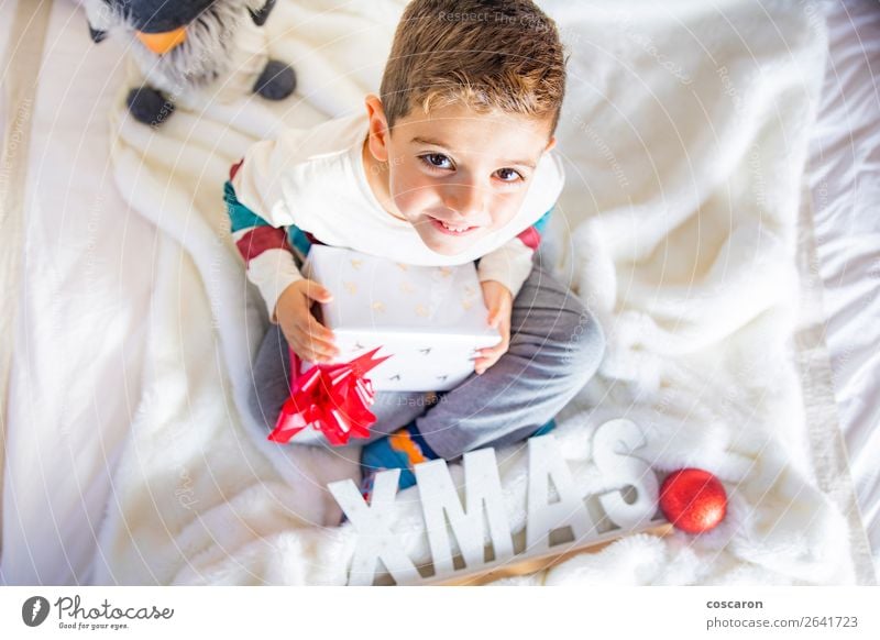 https://www.photocase.com/photos/2641723-little-kid-on-christmas-day-on-the-bed-with-a-gift-photocase-stock-photo-large.jpeg