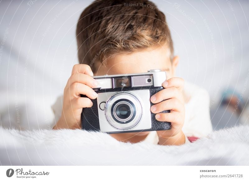 Beautiful boy with a photographing camera in the bed Lifestyle Joy Happy Face Vacation & Travel Room Bedroom Child Camera Technology Human being Baby Toddler