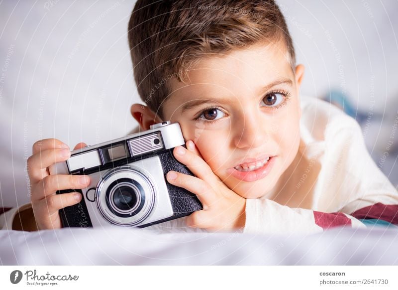 Beautiful boy with a photographing camera in the bed Lifestyle Joy Happy Face House (Residential Structure) Room Bedroom Education Child Apprentice