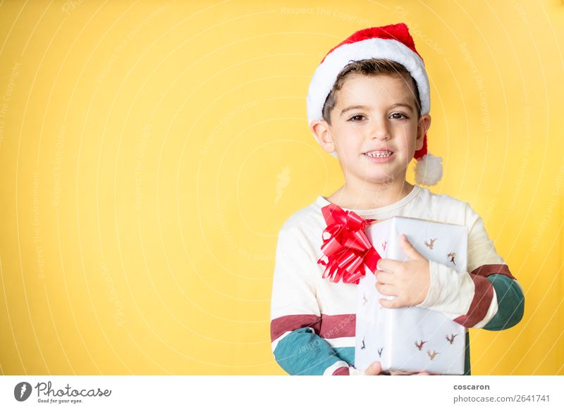 Little kid with a gift on a yellow background on Christmas Day Style Design Joy Happy Beautiful Winter Feasts & Celebrations Christmas & Advent New Year's Eve