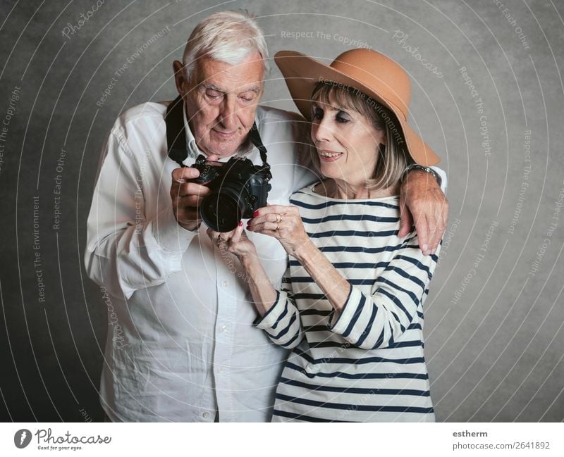 Portrait of happy senior couple with digital camera on gray background Lifestyle Joy Vacation & Travel Trip Cruise Retirement Camera Technology Human being