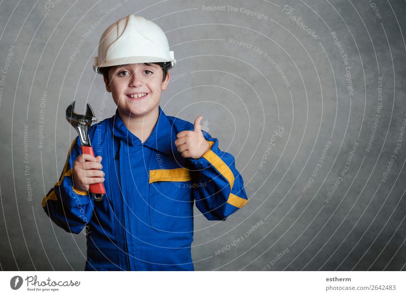 smiling child with a white helmet and holding a wrench Joy Child Work and employment Construction site Tool Hammer Human being Masculine Boy (child) Father