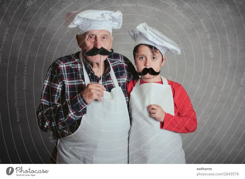 Grandfather With Grandson with cook hat and mustache on gray background Nutrition Diet Lifestyle Joy Leisure and hobbies Kitchen Restaurant