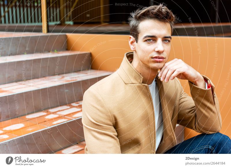 Young man wearing winter clothes in the street sitting Lifestyle Elegant Style Beautiful Hair and hairstyles Winter Human being Man Adults Youth (Young adults)
