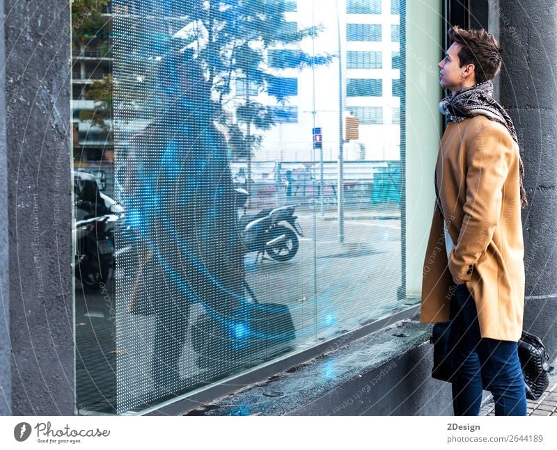 Young man wearing winter clothes in the street looking a display Lifestyle Elegant Style Beautiful Hair and hairstyles Winter Human being Man Adults