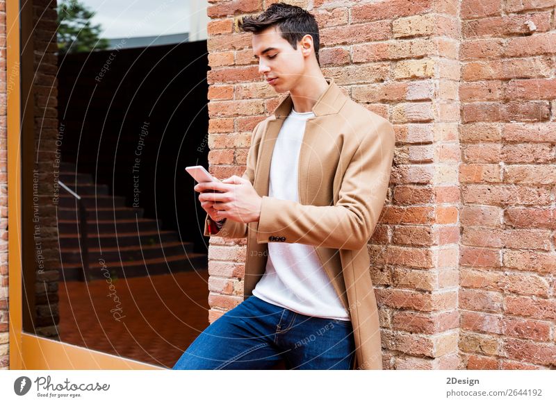 Modern young man with mobile phone in the street. Elegant Style Beautiful Hair and hairstyles Winter Telephone PDA Human being Man Adults Youth (Young adults)