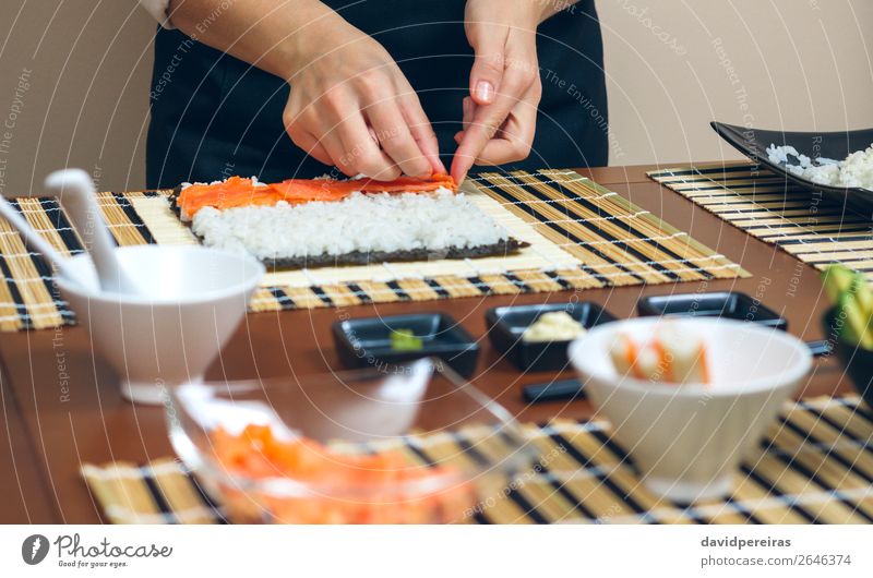 Chef hands placing ingredients on rice Seafood Diet Sushi Bowl Restaurant Human being Woman Adults Hand Make Fresh chef careful Salmon Rice maki roll crab stick