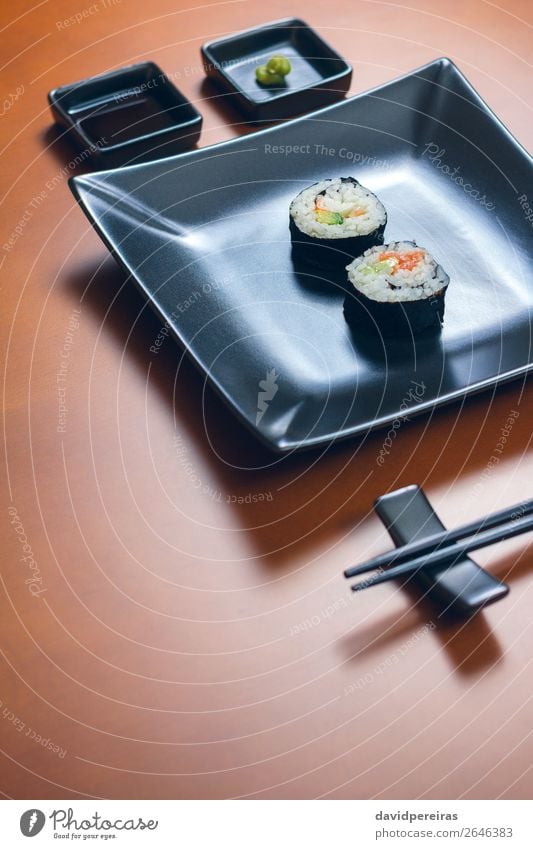 Sushi maki rolls on a tray Lunch Dinner Plate Elegant Restaurant Woman Adults Delicious japanese asian food Menu california roll wood table Chopstick