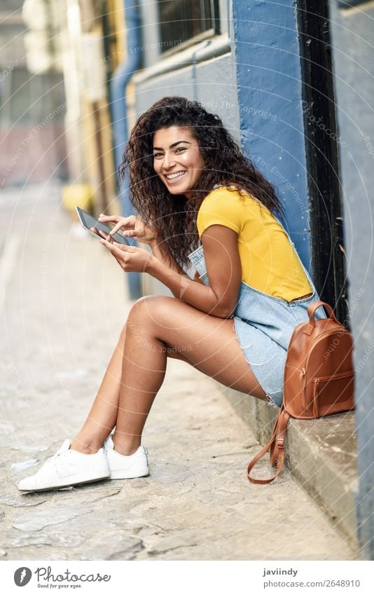 Happy Arab woman sitting on urban step with a digital tablet Lifestyle Style Beautiful Hair and hairstyles Tourism Technology Human being Feminine Young woman
