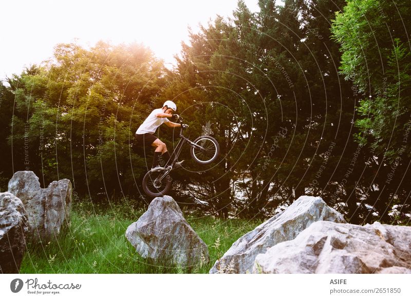 Young trial bycicler making tricks in a rock circuit Freedom Summer Mountain Sports Cycling Man Adults Nature Tree Forest Rock Jump Strong Rider bike Extreme
