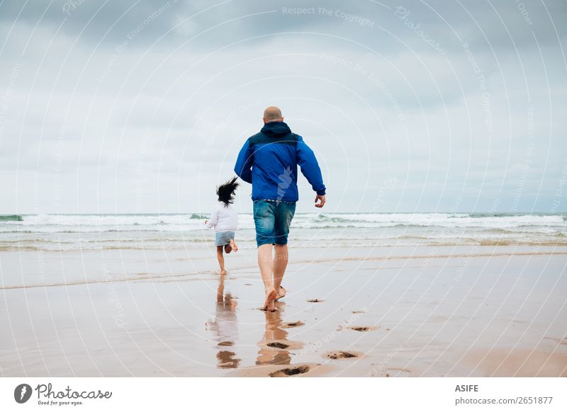 Father and daughter playing on the beach in a cloudy day Joy Happy Leisure and hobbies Playing Beach Ocean Child Parents Adults Family & Relations Clouds
