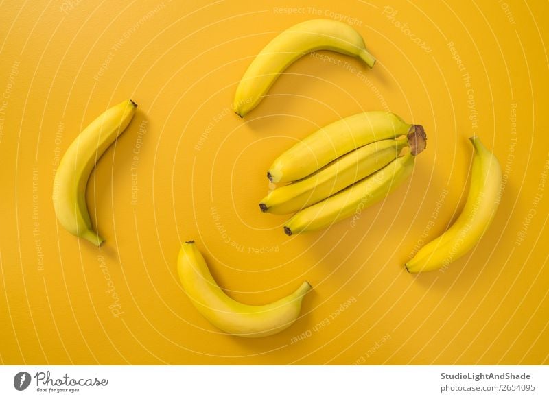 Bananas on bright yellow background Fruit Nutrition Vegetarian diet Diet Design Exotic Joy Happy Healthy Eating Summer Nature Simple Fresh Bright Modern Natural