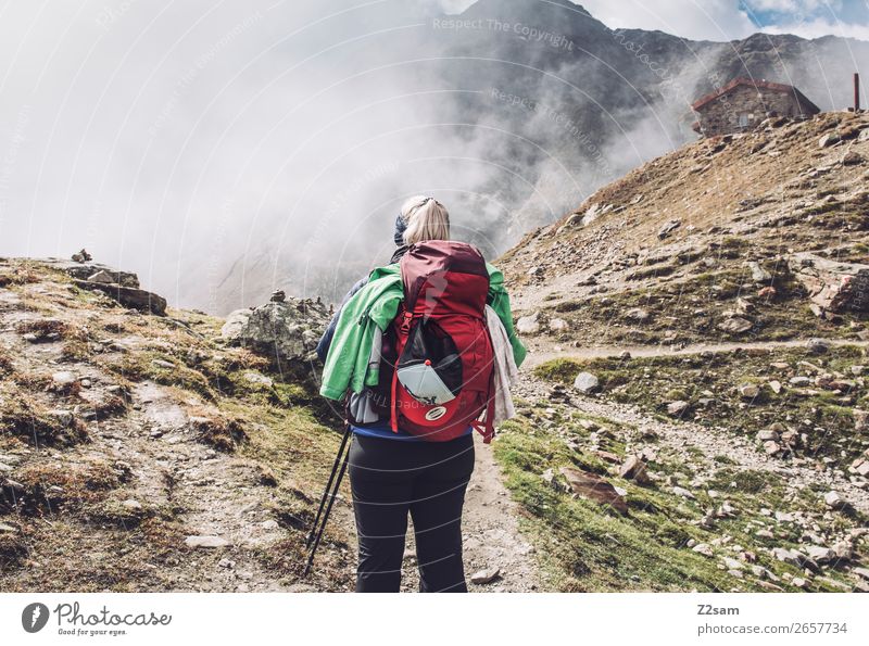 Young woman hiking, Timmelsjoch E5. Vacation & Travel Expedition Hiking Youth (Young adults) Nature Landscape Sky Clouds Autumn Beautiful weather Fog Alps