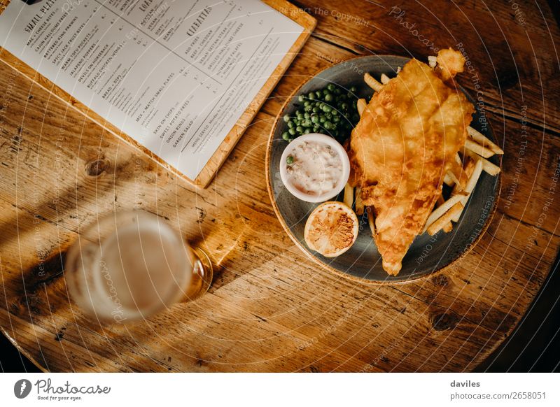 Fish and chips Food Seafood Lunch Beer Table Restaurant Eating Wood Gold Tradition Sauce British Potatoes Meal Peas Frying Dish Tartar Menu Pub Tavern Lemon