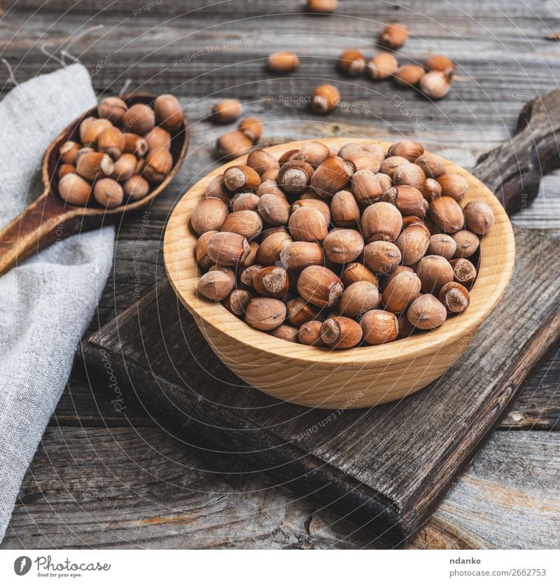 hazelnut nuts in a brown wooden bowl Fruit Nutrition Vegetarian diet Bowl Table Wood Old Eating Fresh Natural Brown dry Edible filbert food Heap husk