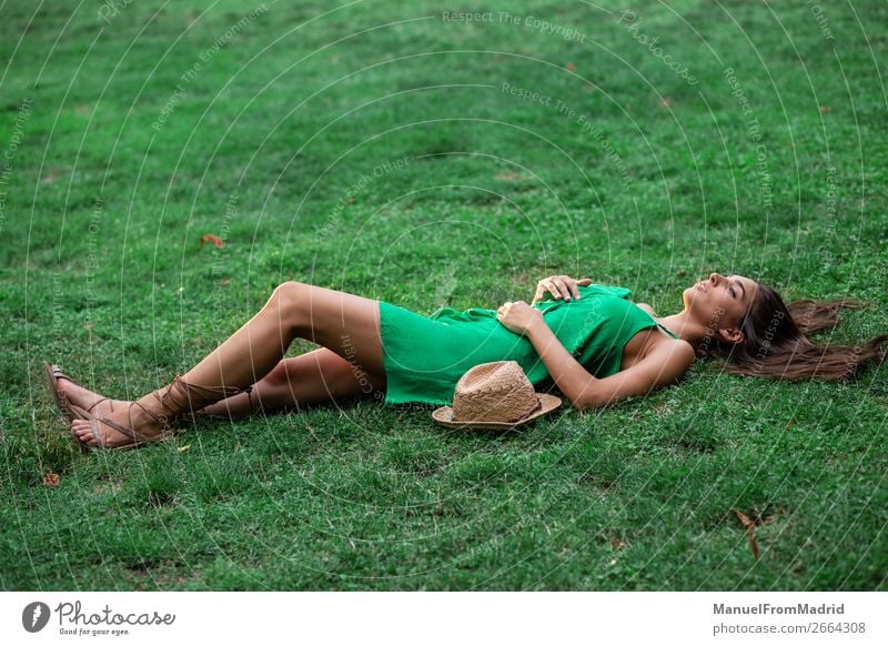 young cheerful woman lying down on the grass - a Royalty Free Stock Photo  from Photocase