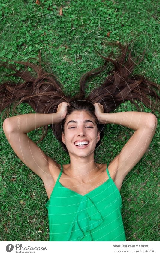 Young Cheerful Woman Lying Down On The Grass A Royalty Free Stock