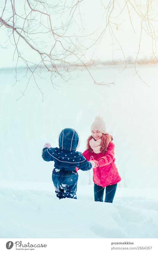 Teenage girl enjoying snow with her little sister Lifestyle Joy Happy Winter Snow Winter vacation Human being Child Toddler Girl Woman Adults Mother