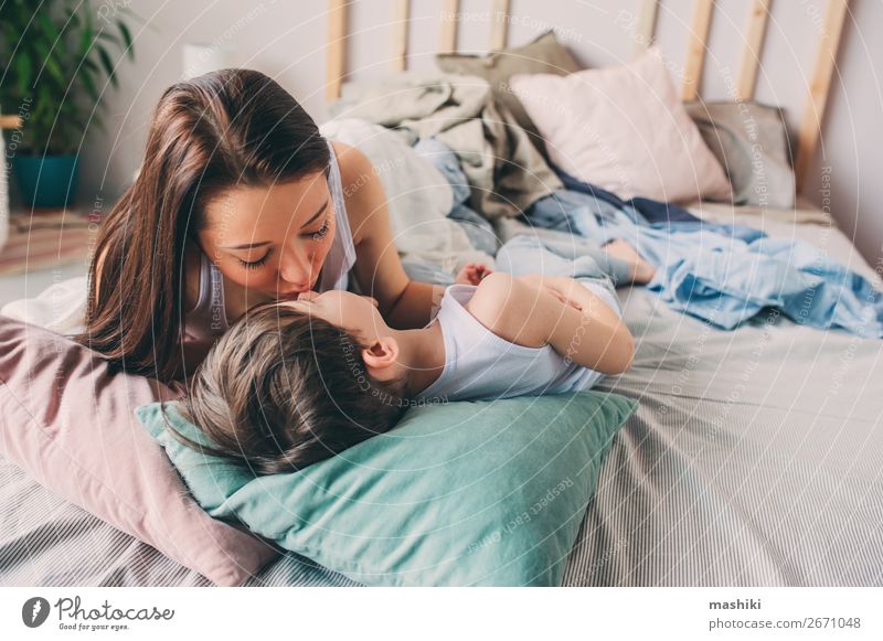 Mother Kisses Her Toddler Son In Bed For Good Night A
