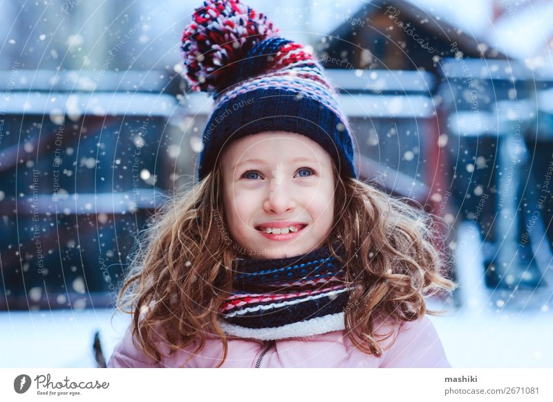 Foto de Cute little funny toddler girl in colorful winter fashion clothes  having fun and playing with snow, outdoors during snowfall. Active outdoors  leisure with children. Happy healthy child do Stock