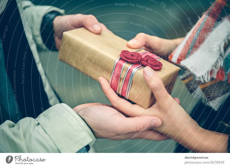 Man hands giving gift box to woman with scarf Lifestyle Happy Winter Feasts & Celebrations Birthday Human being Woman Adults Couple Hand Autumn Flower Street