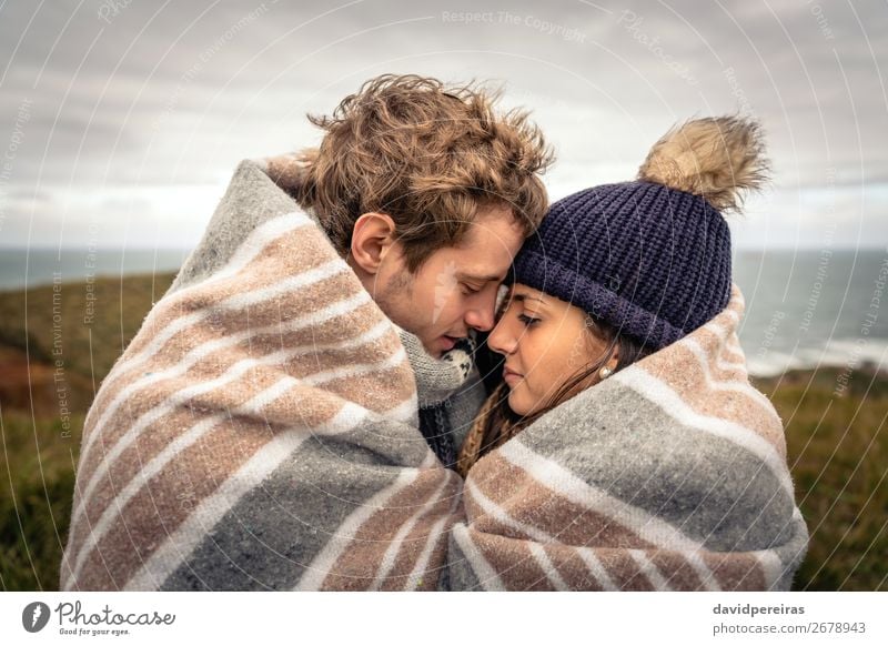 Young couple embracing outdoors under blanket in a cold day Lifestyle Beautiful Ocean Winter Mountain Woman Adults Man Couple Nature Sky Clouds Autumn Meadow