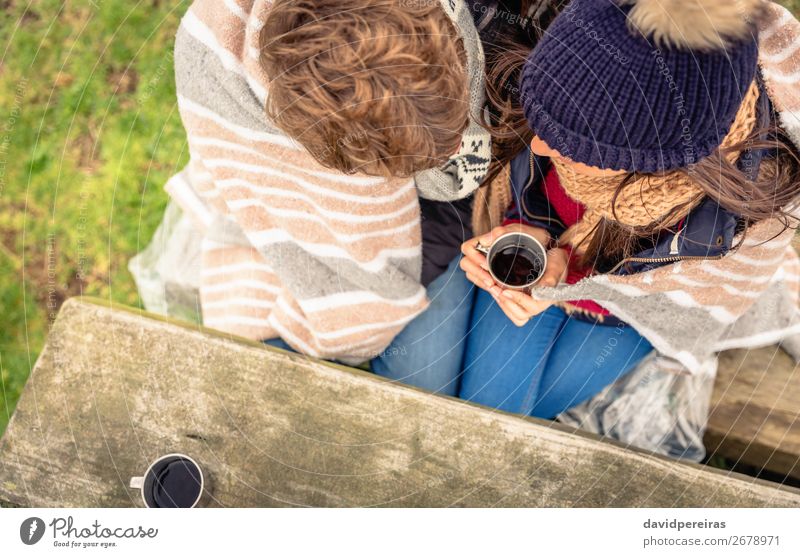 Young couple under blanket having hot drink in a cold day Beverage Coffee Tea Lifestyle Happy Winter Mountain Table Woman Adults Man Couple Hand Nature Autumn