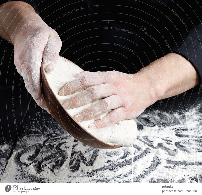 man's hands knead white wheat flour dough Dough Baked goods Bread Nutrition Plate Table Kitchen Cook Man Adults Hand Wood Make Fresh Black White Tradition