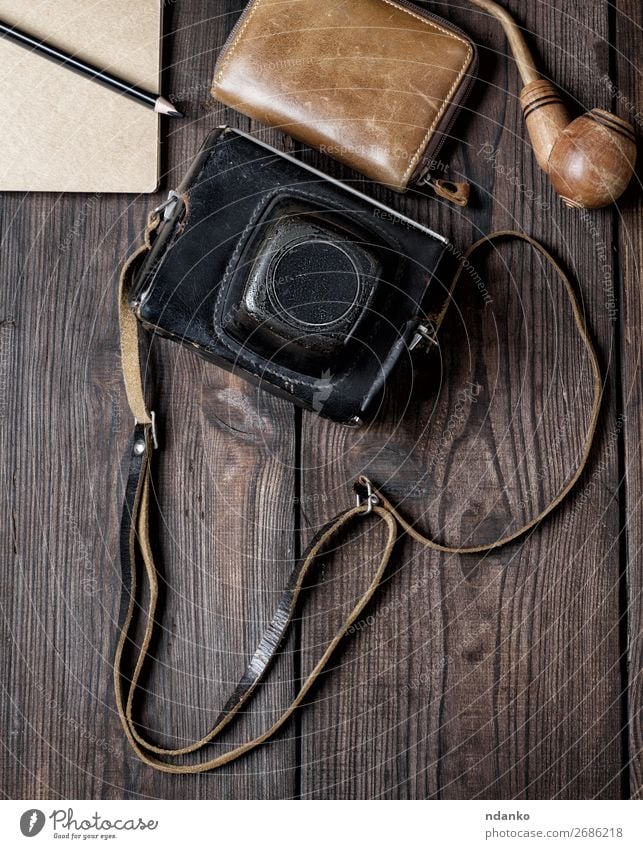 old vintage camera in a case on a wooden background Lifestyle Vacation & Travel Trip Camera Leather Accessory Wood Old Retro Brown Black Adventure casual