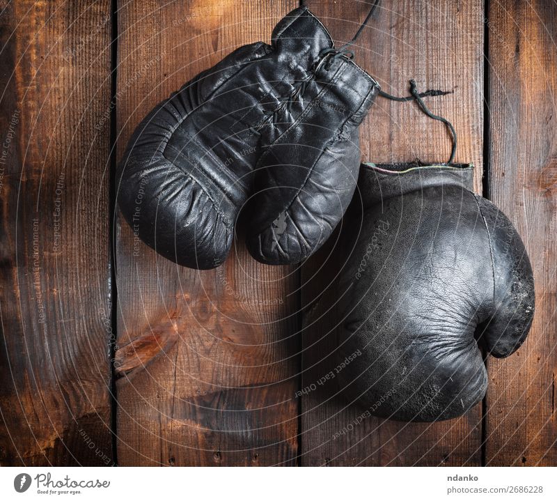 very old black boxing gloves Sports Leather Ring Gloves Wood Old Fitness Retro Brown Black Protection Competition Gymnasium Action Ancient Antique background