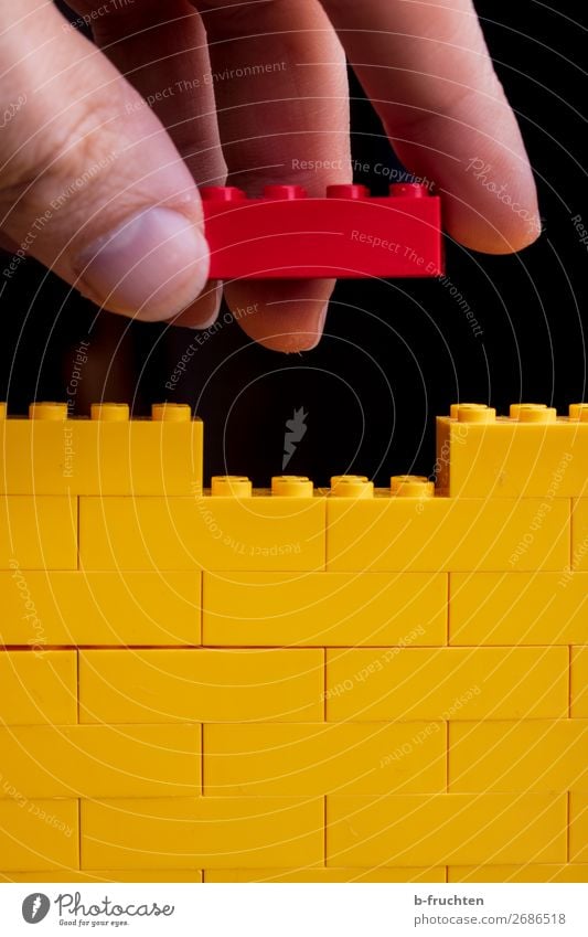 game bricks, yellow wall, red brick in hand Playing Model-making House building Redecorate Craftsperson Craft (trade) Construction site Fingers Toys Plastic