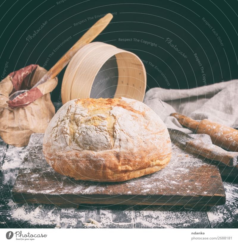 baked round white wheat bread Dough Baked goods Bread Knives Spoon Table Kitchen Sieve Wood Make Dark Fresh Brown Black White Tradition Baking Bakery board