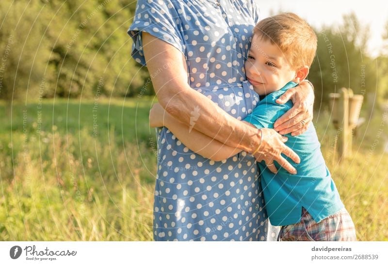 Happy grandson hugging to his grandmother outdoors Lifestyle Relaxation Leisure and hobbies Summer Garden Child Human being Boy (child) Woman Adults Man Parents