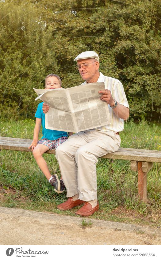 Senior man and bored child reading newspaper outdoors Lifestyle Happy Relaxation Leisure and hobbies Reading Child School Human being Boy (child) Man Adults