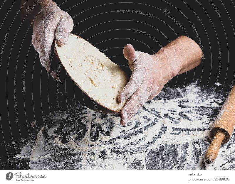 male hand holding a ceramic plate with yeast dough Dough Baked goods Bread Nutrition Plate Table Kitchen Cook Man Adults Hand Wood Make Fresh Black White