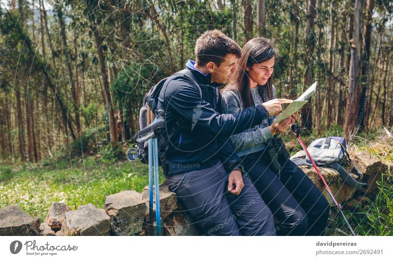 Couple doing trekking sitting looking at a map Leisure and hobbies Trip Adventure Sightseeing Mountain Hiking Sports Human being Woman Adults Man Nature