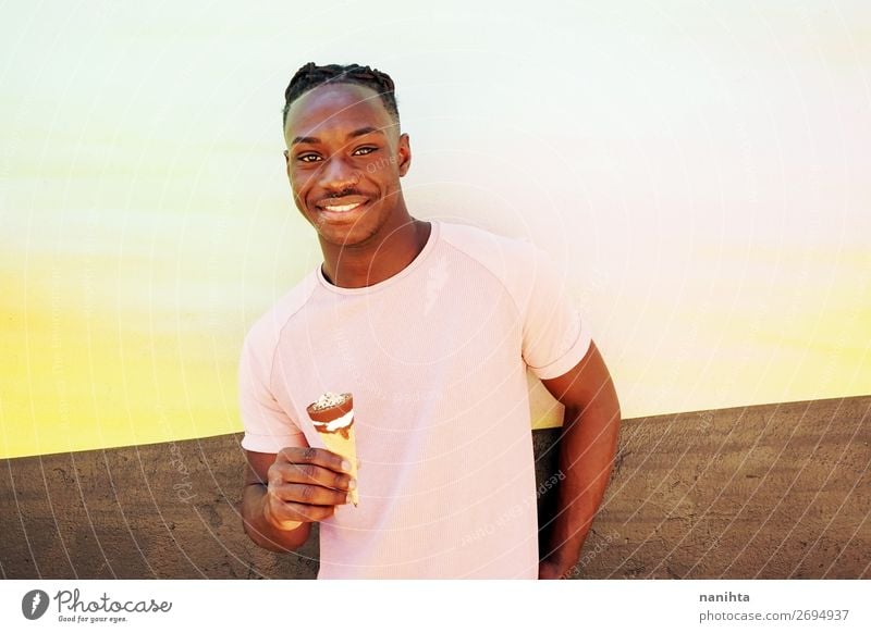 Young handsome black man holds a ice cream Food Dessert Ice cream Nutrition Eating Fast food Style Happy Summer Sunbathing Human being Masculine Young man