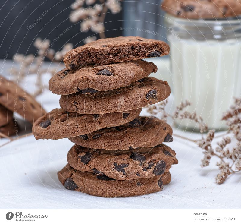 stack of round chocolate cookies and milk Cake Dessert Candy Breakfast Beverage Milk Glass Table Dark Fresh Small Brown White Tradition biscuit Token Dairy