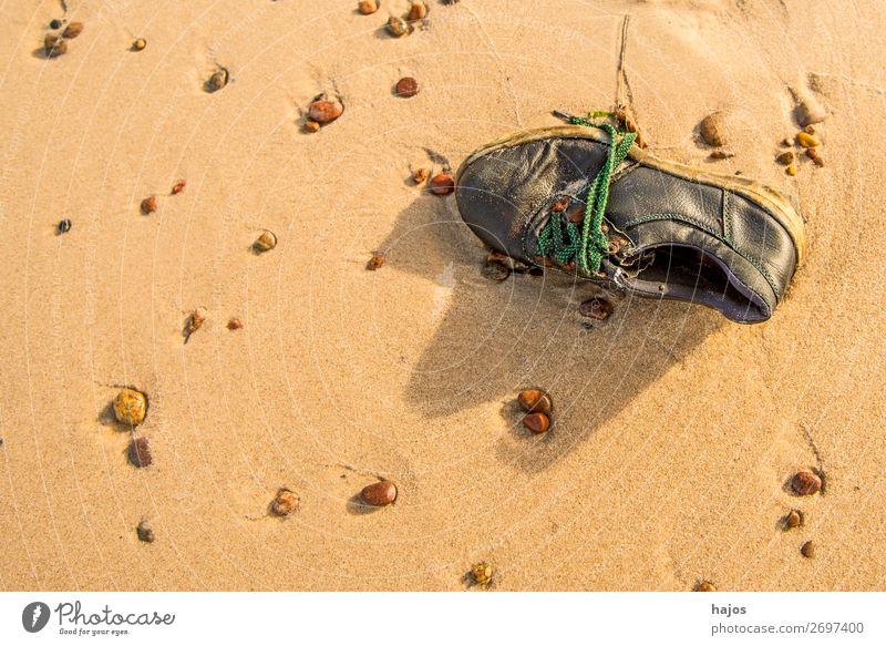 old, lost shoe on the beach Summer Beach Sand Sun Baltic Sea Brown Sadness Old Doomed Sandy beach find stones pebble still life vacation Colour photo