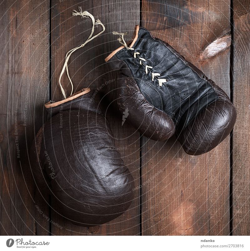 very old brown boxing gloves Sports Leather Gloves Wood Old Fitness Retro Brown Black Protection Competition Action Ancient Antique background boxer Boxing